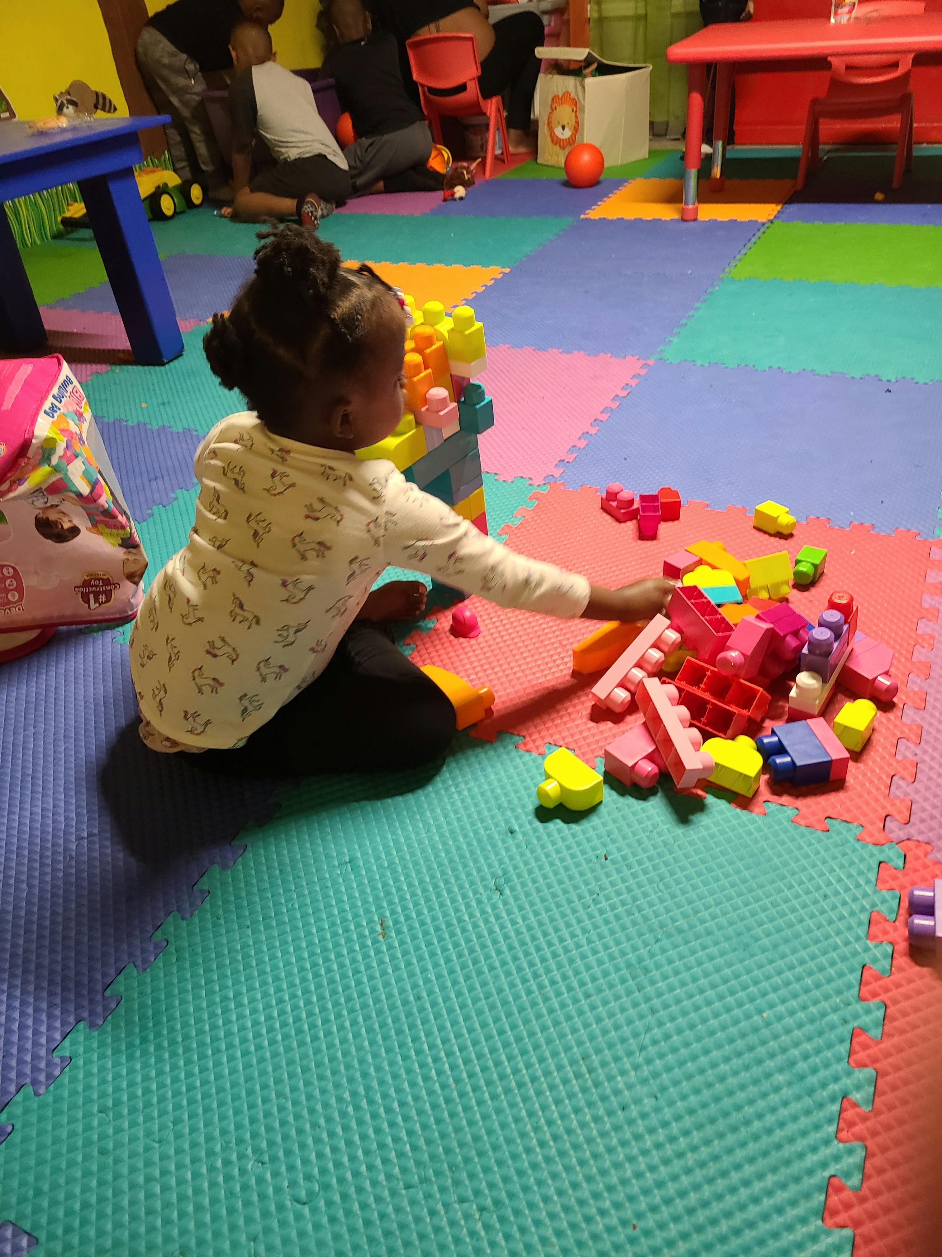 Child playing with colorful building blocks on a mat