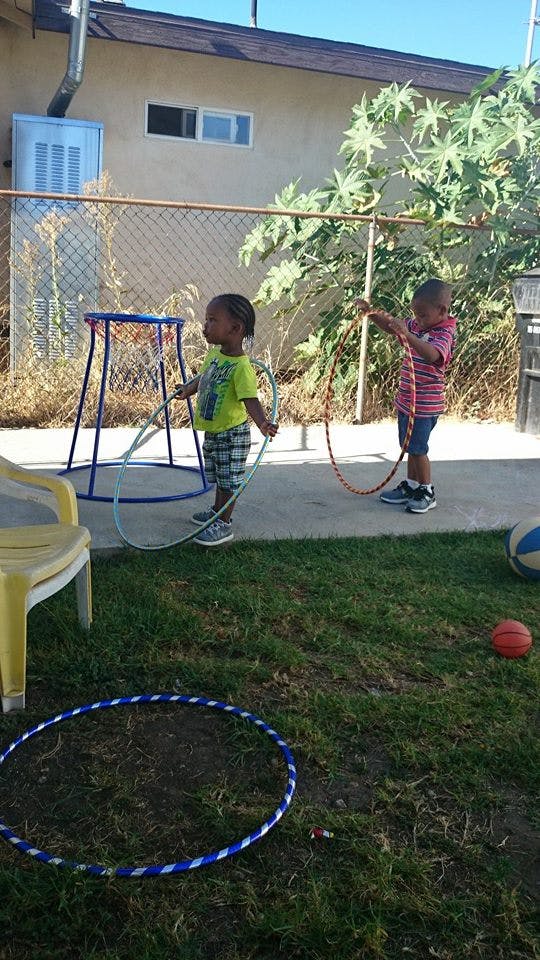 Two children playing with hula hoops outdoors