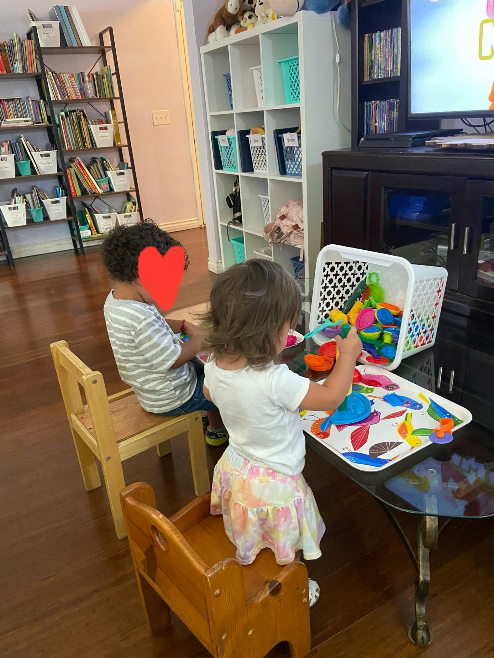 Two children playing with colorful toys at a table