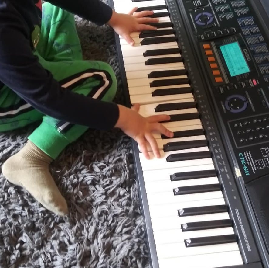 Child's hands playing a keyboard