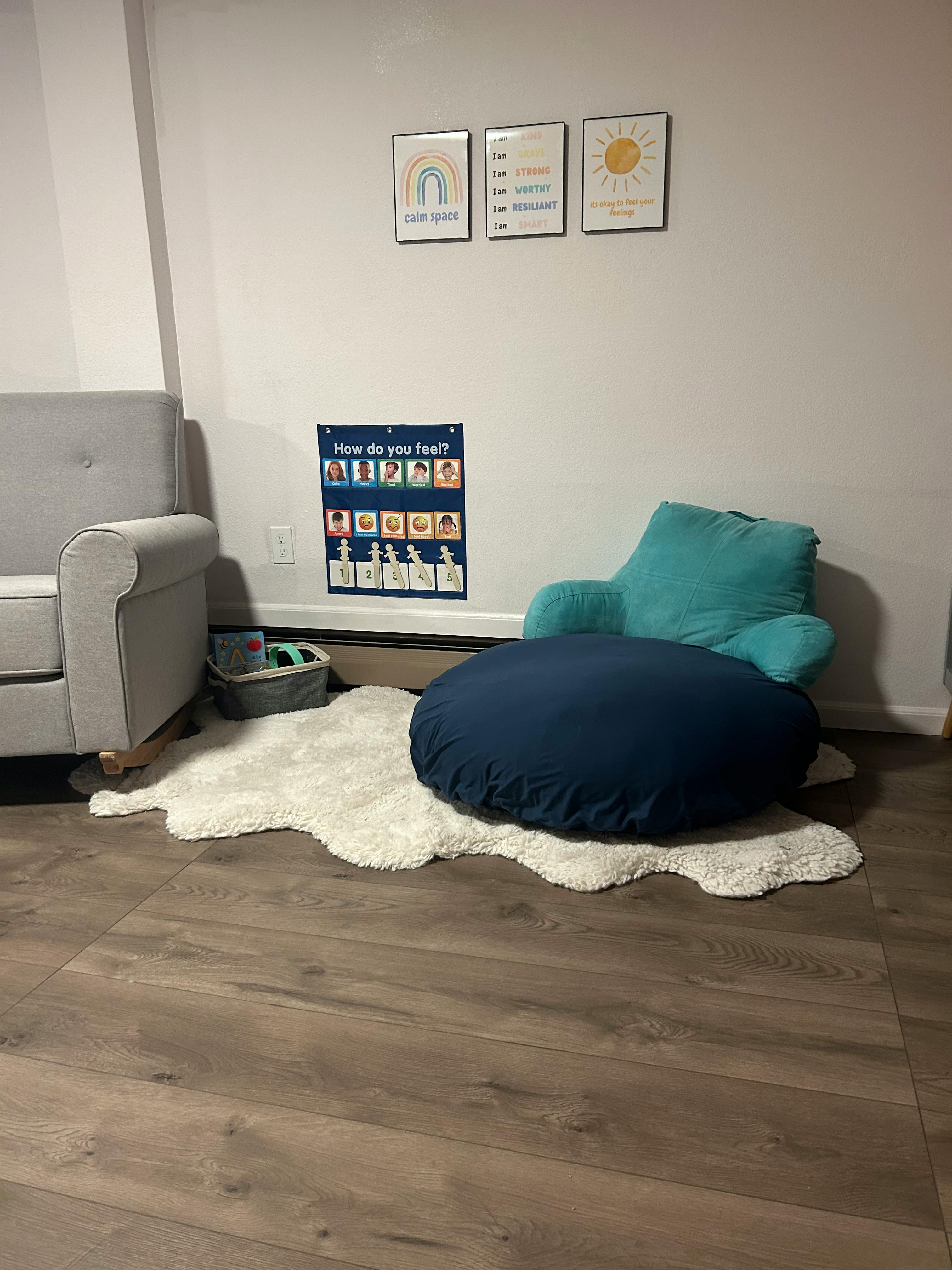 Seating area with a gray sofa, a blue beanbag chair, and a white rug