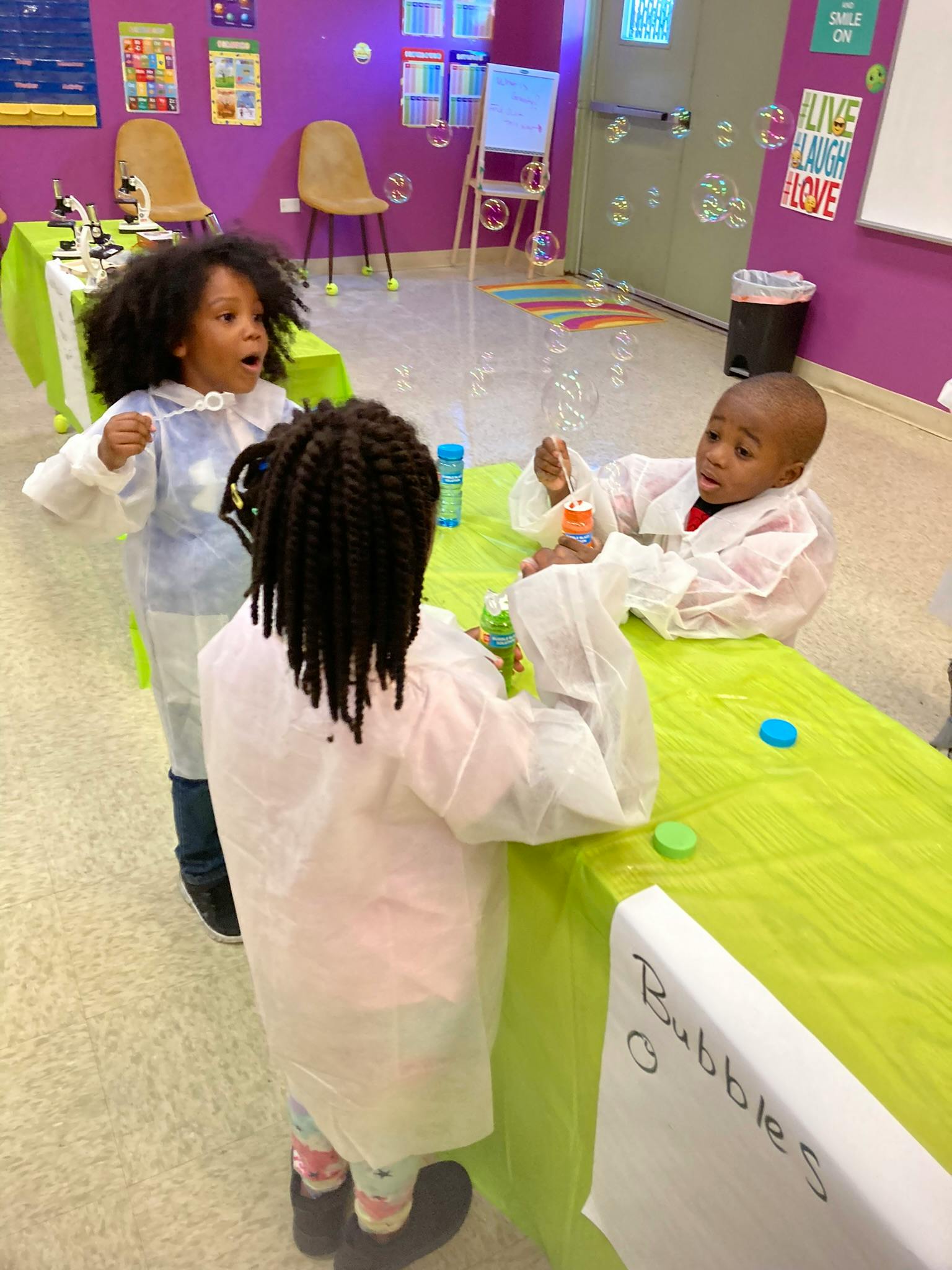 Children in lab coats playing with bubbles