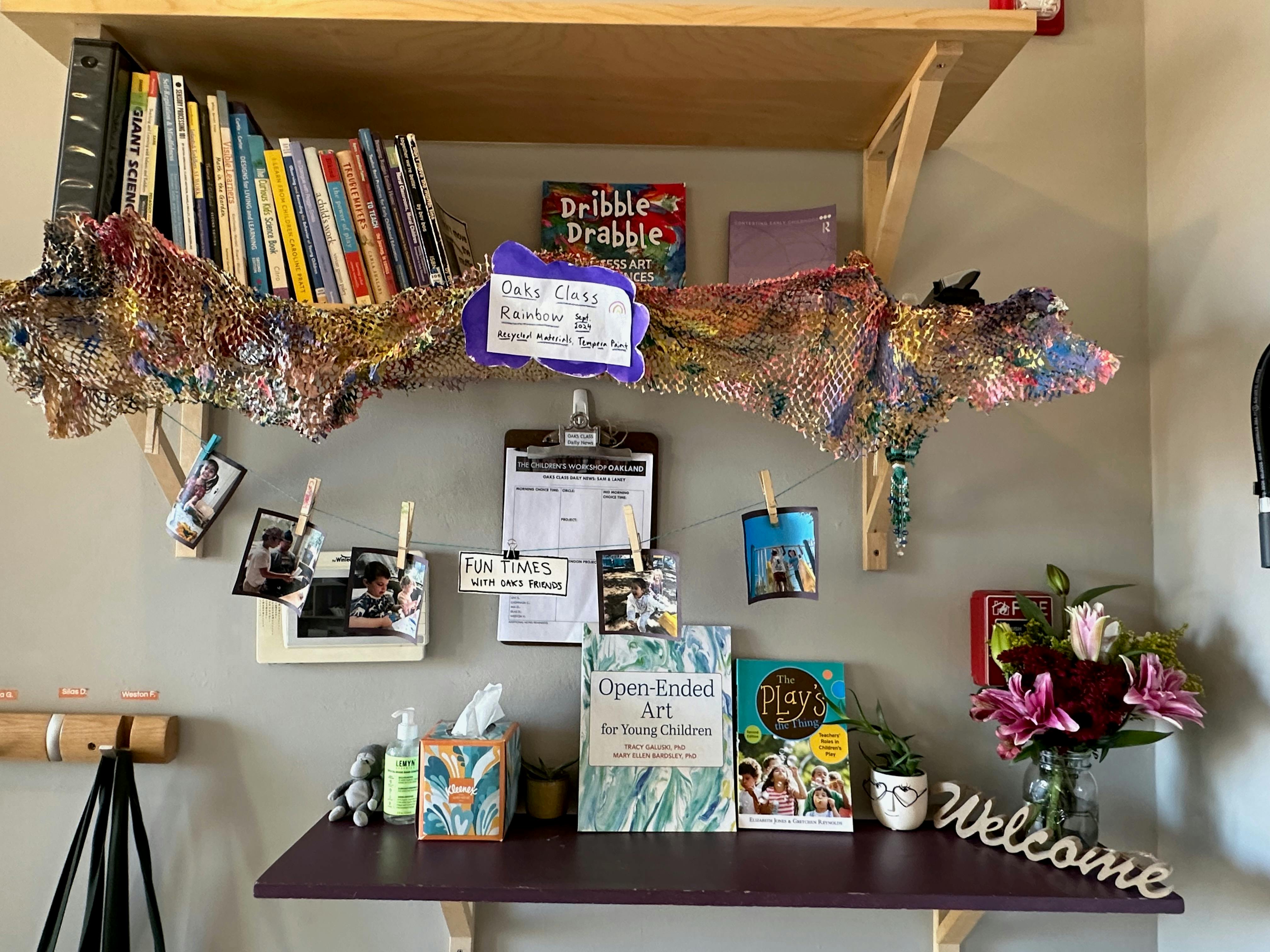 Shelf with books, clipboard, photos, and a welcome sign
