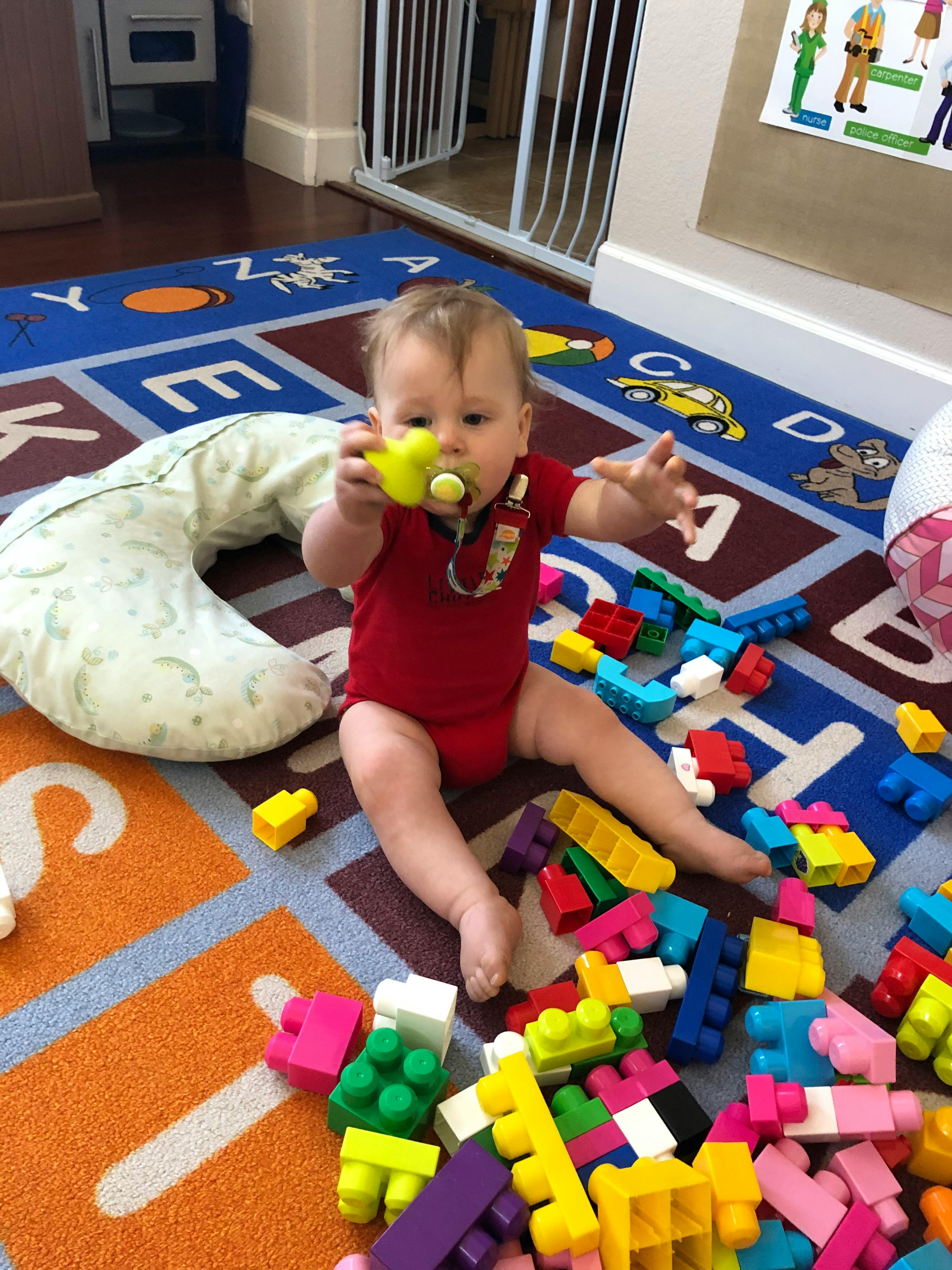 Child playing with colorful building blocks on a rug
