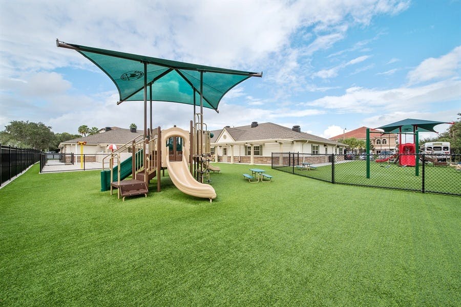 Playground with slides and shade structure on artificial turf