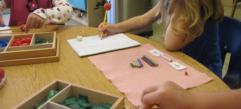 Children working at a table with learning materials