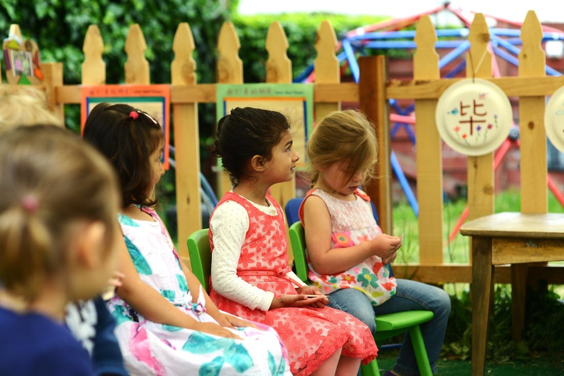 Children sitting in chairs outdoors