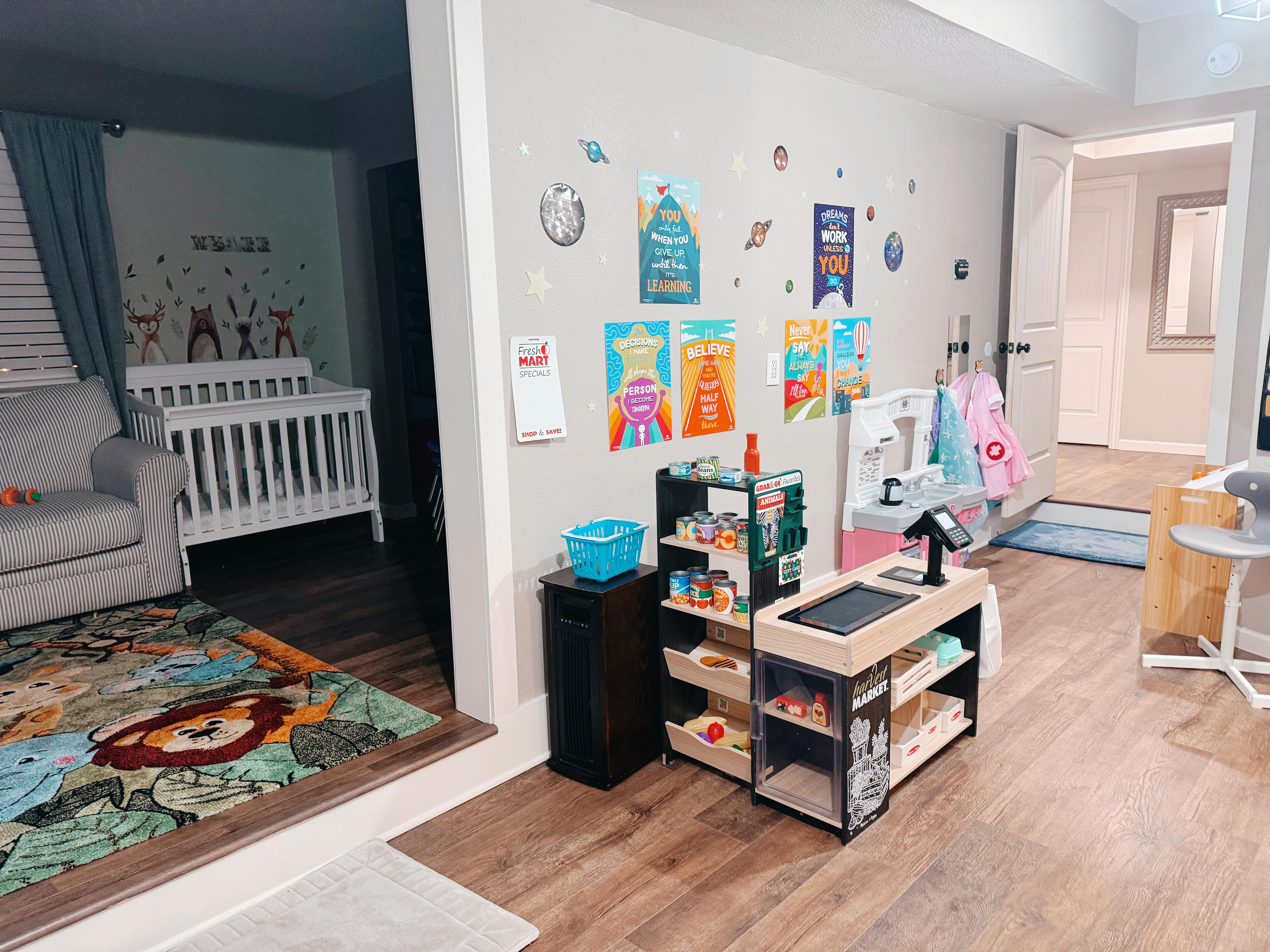 Nursery with a crib and a play area with shelves and posters