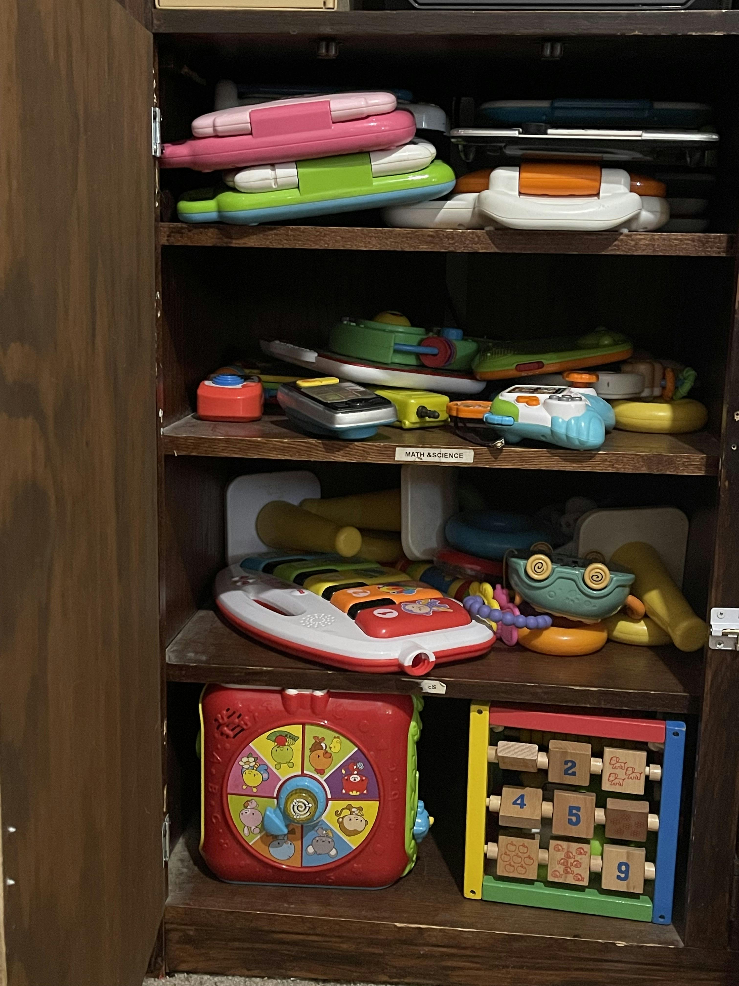 Cabinet shelves filled with various colorful toys and learning games