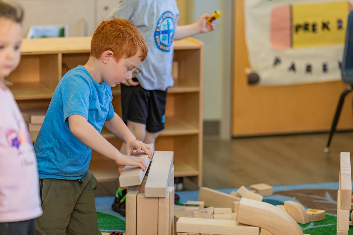 Child building with wooden blocks in a classroom
