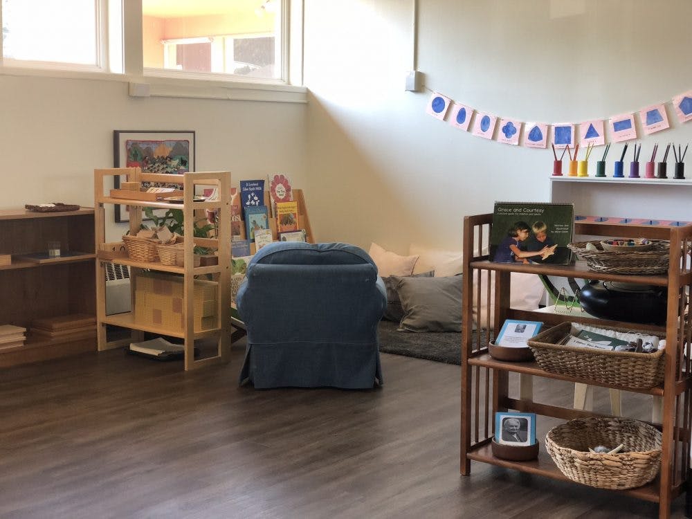 Classroom with shelves of learning materials, a blue chair, and banner