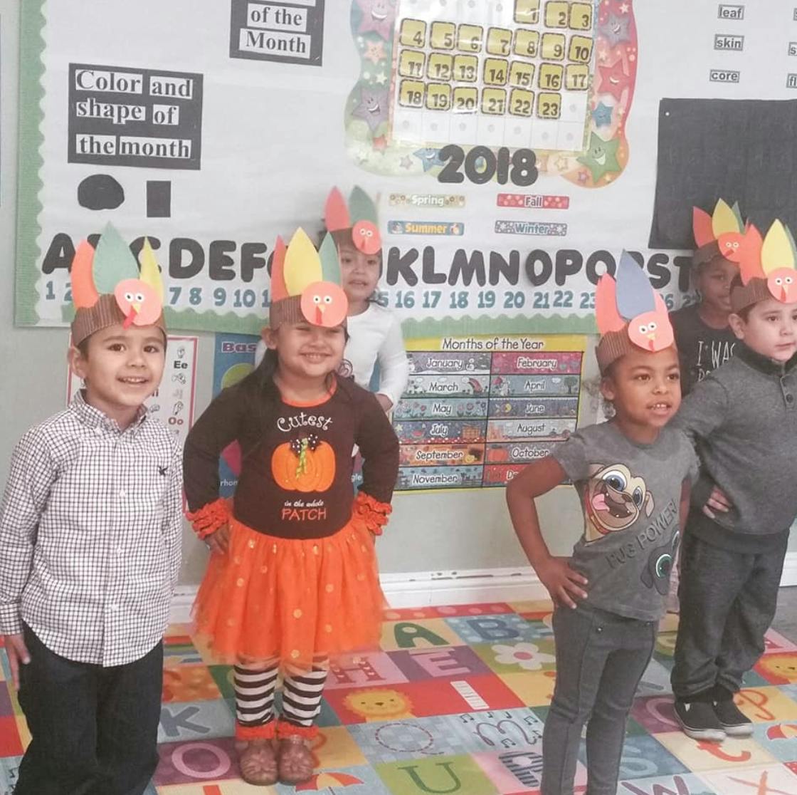 Children wearing paper turkey hats in a classroom