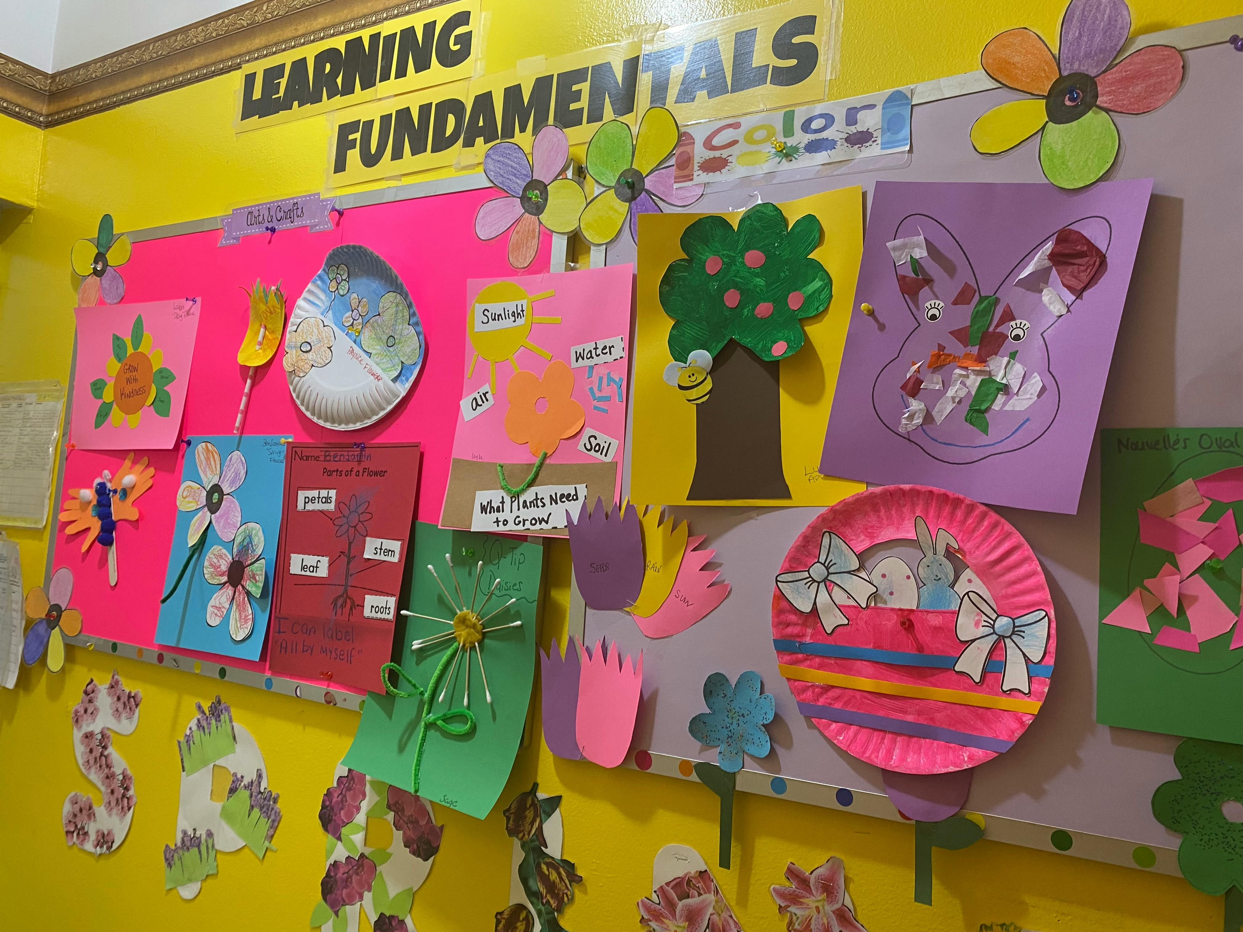 Children's artwork and crafts displayed on a classroom wall