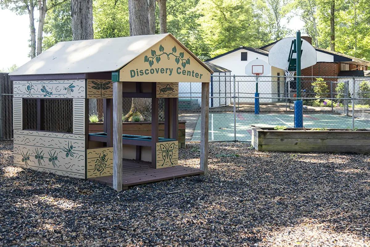 Discovery Center playhouse on a playground with a basketball court