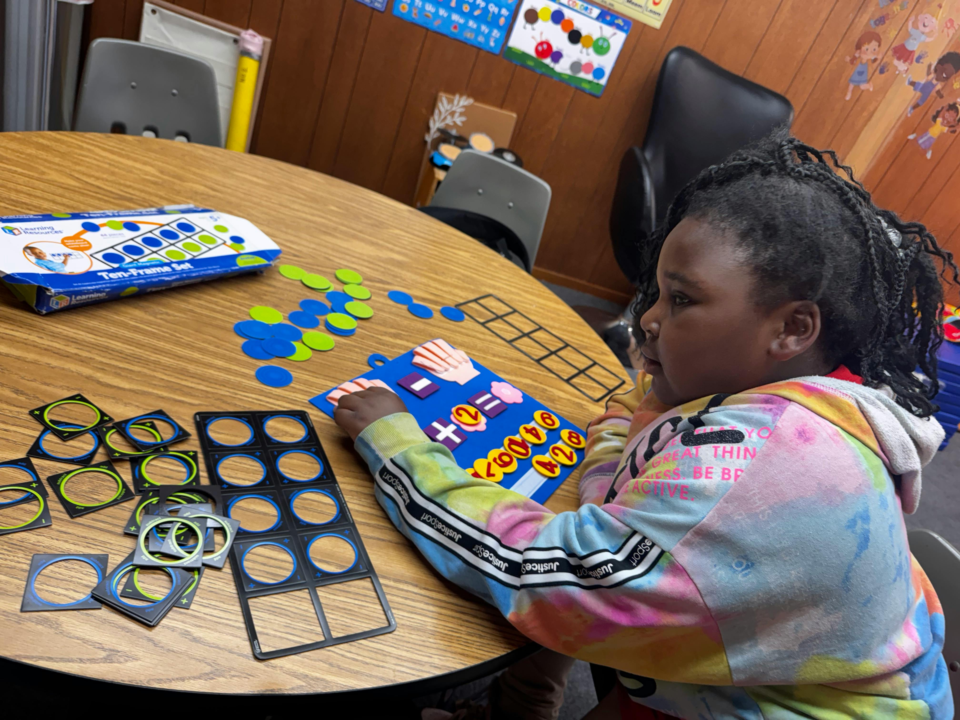 Child playing with a math learning toy at a table