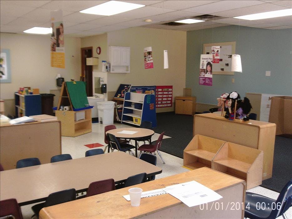 Empty classroom with tables, chairs, and shelves