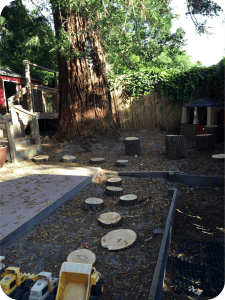 Outdoor play area with tree stumps and sandboxes