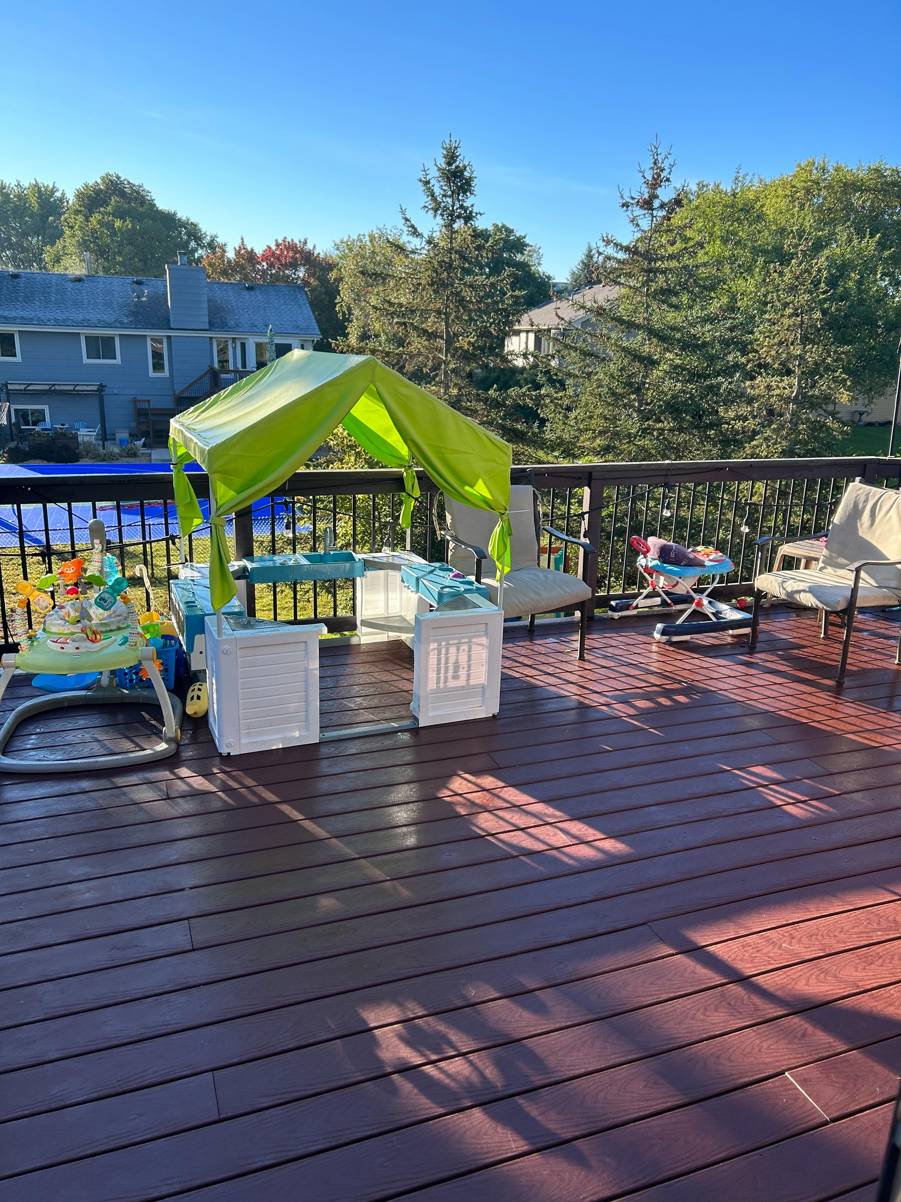 Green canopy over a play area on a wooden deck
