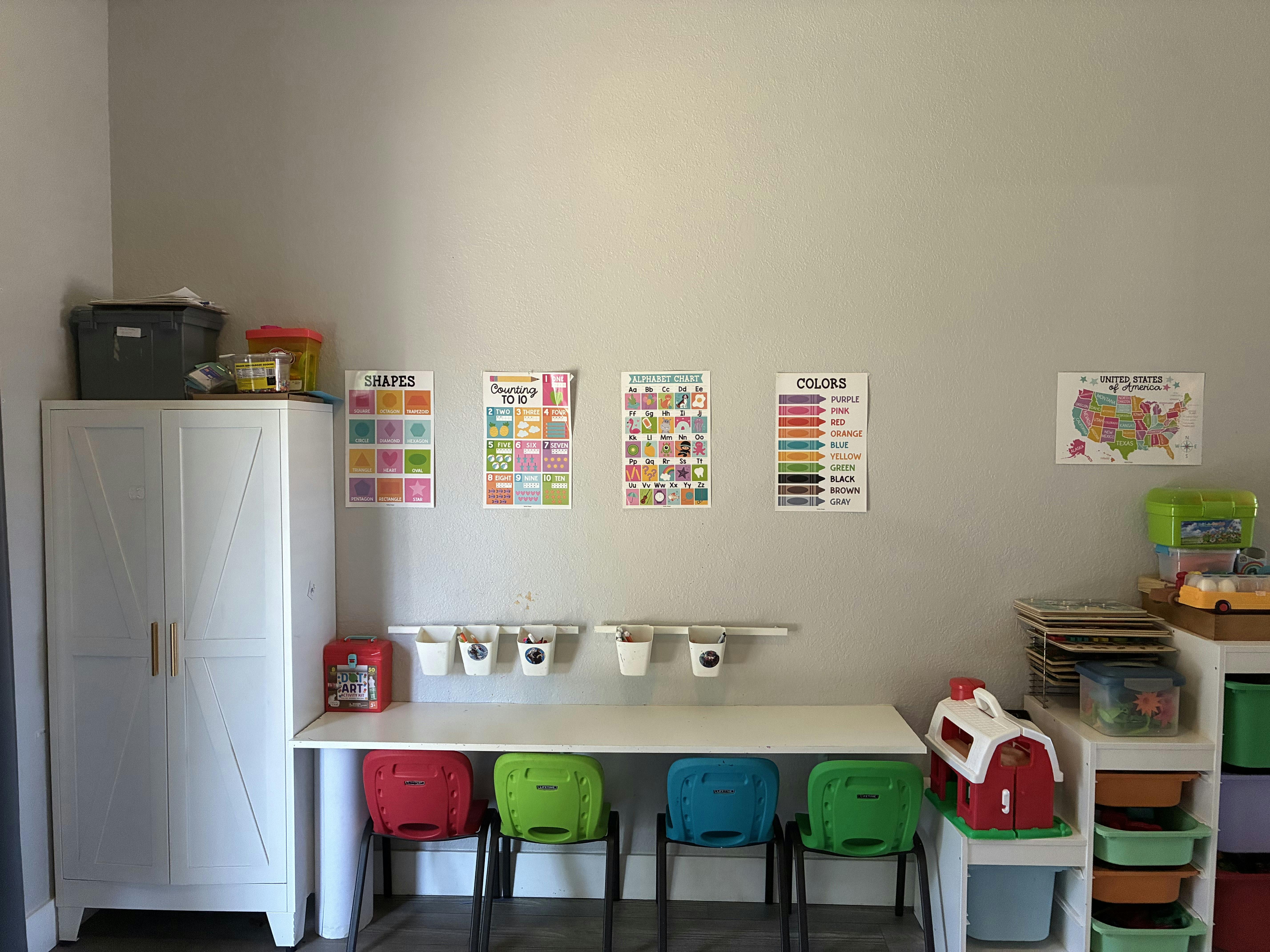 Child desk with four small colorful chairs and educational wall charts