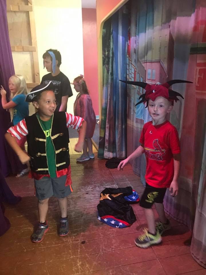 Two children in costumes, one dressed as a pirate and one in a red hat