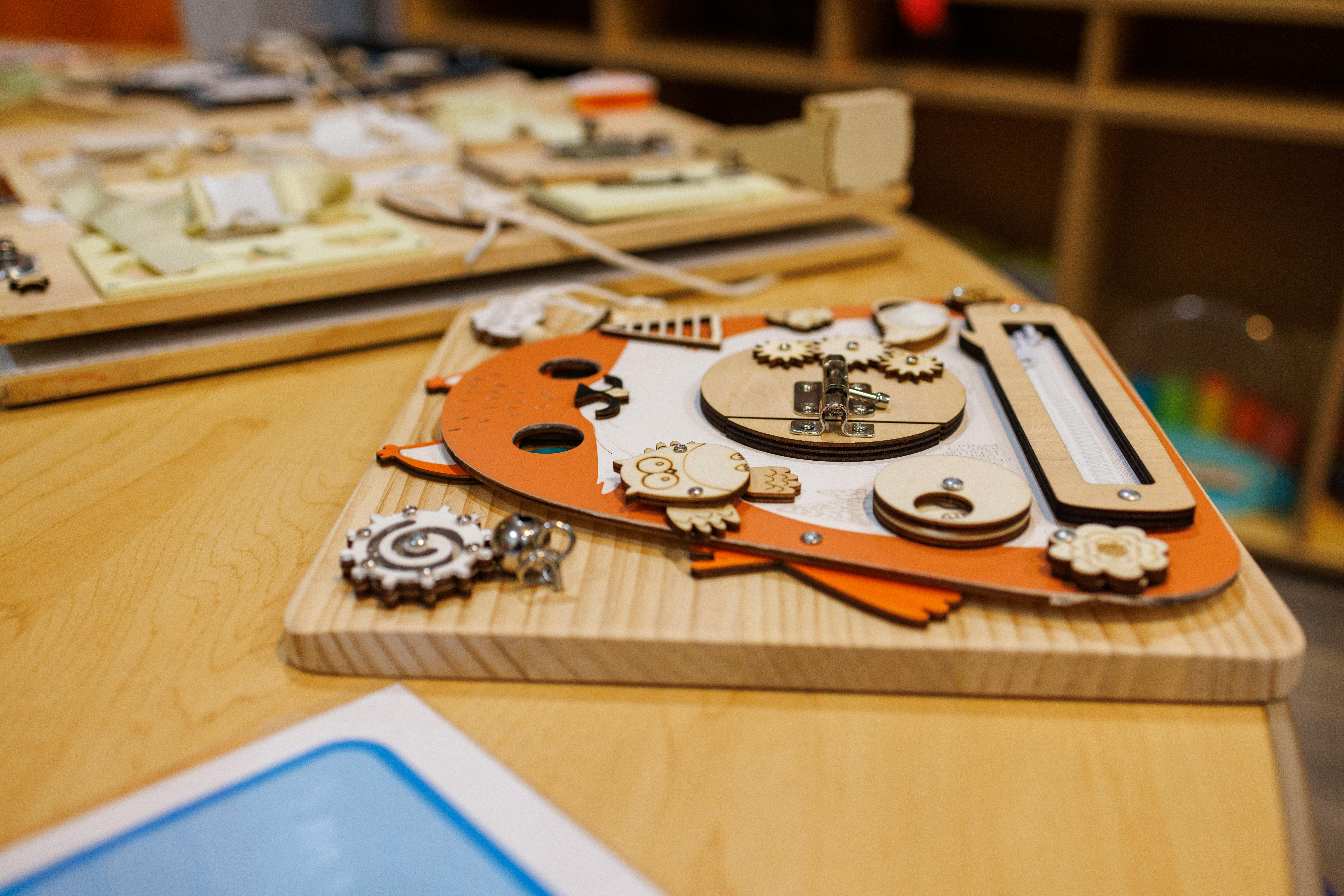 Wooden busy board with various shapes and gears