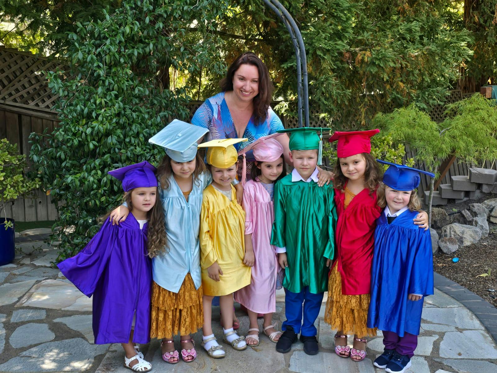 Person with children wearing graduation caps and gowns