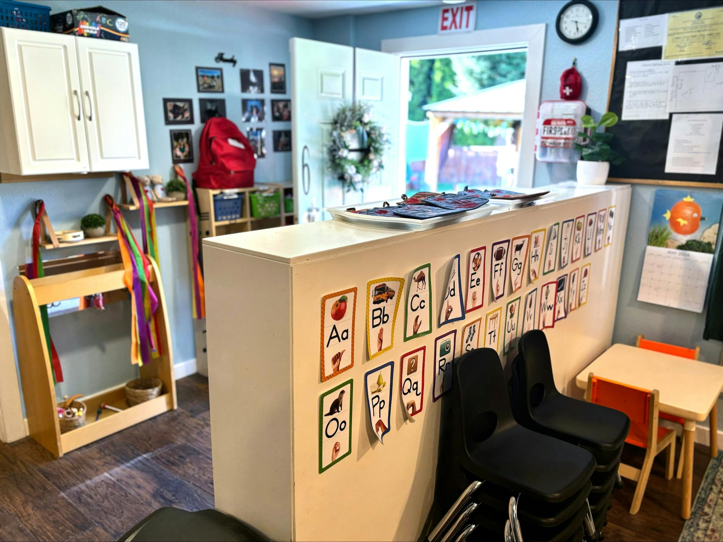 Classroom with alphabet cards on a counter and small tables and chairs