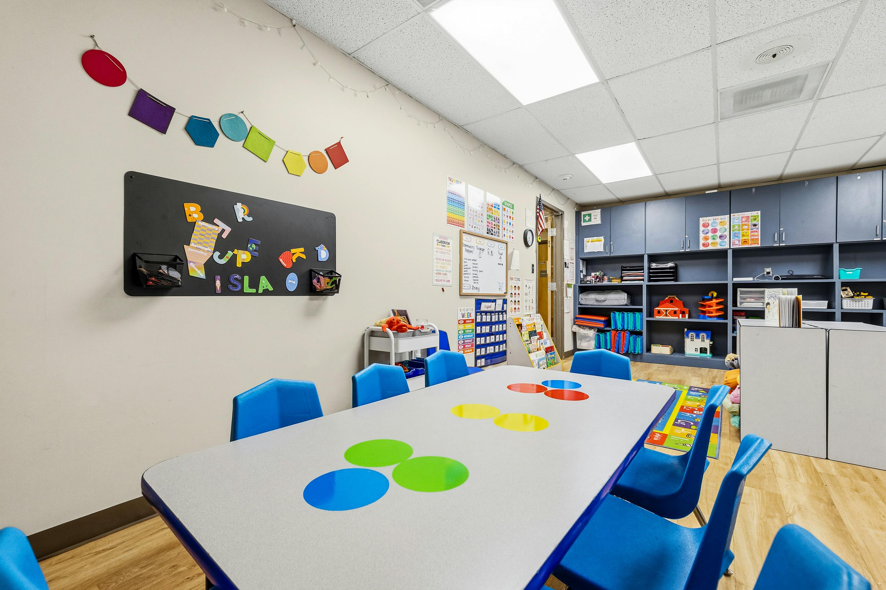 Classroom table with blue chairs and colorful circle decals