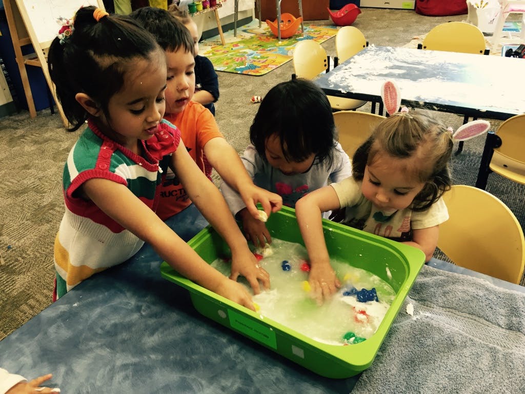 Children playing with toys in a water table