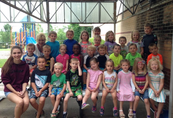 Group of adults and children posing for a photo outdoors