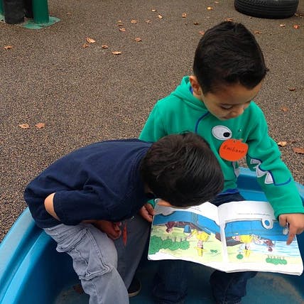 Two children looking at a book together