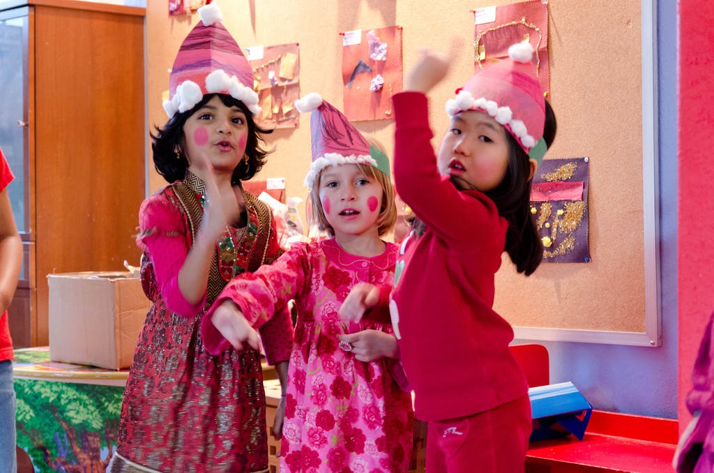 Three children in festive hats and clothing