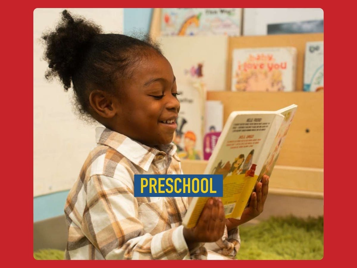 Child in a plaid shirt reading a book