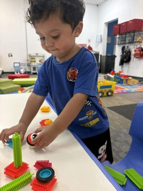Child building with colorful plastic blocks at a table