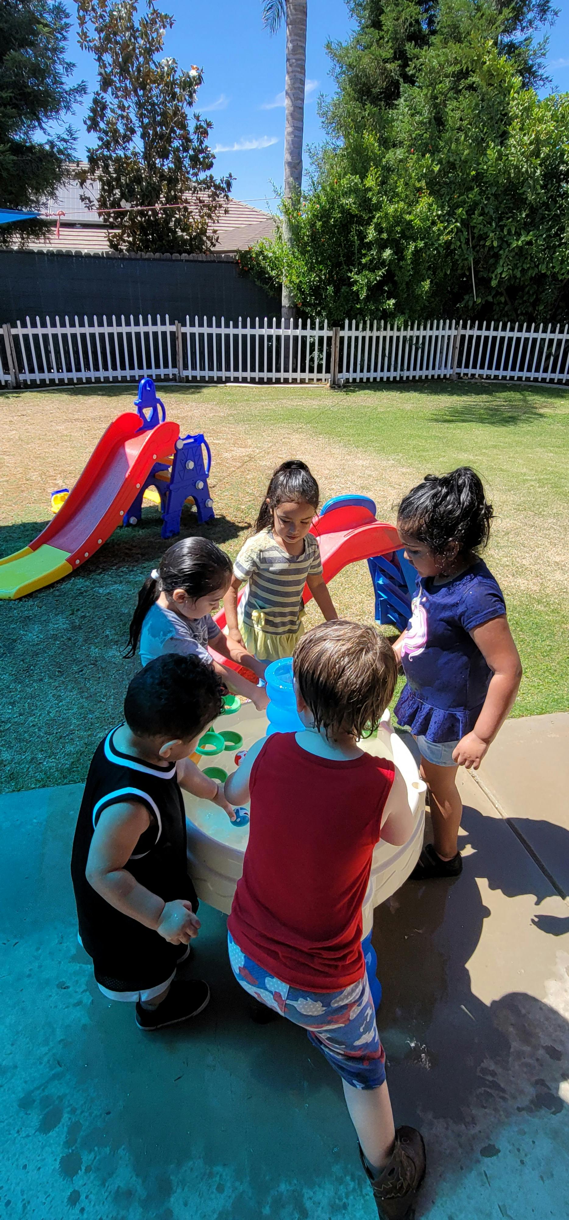 Children playing at a water table outdoors