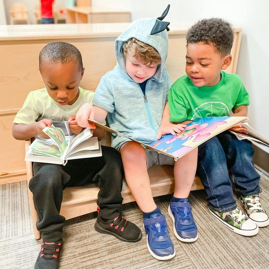 Three children sitting together and reading books