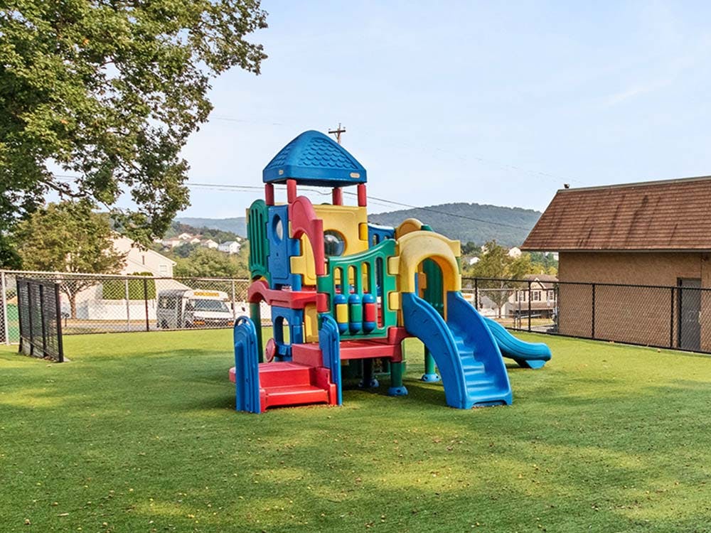 Playground with colorful structure and slides on green turf