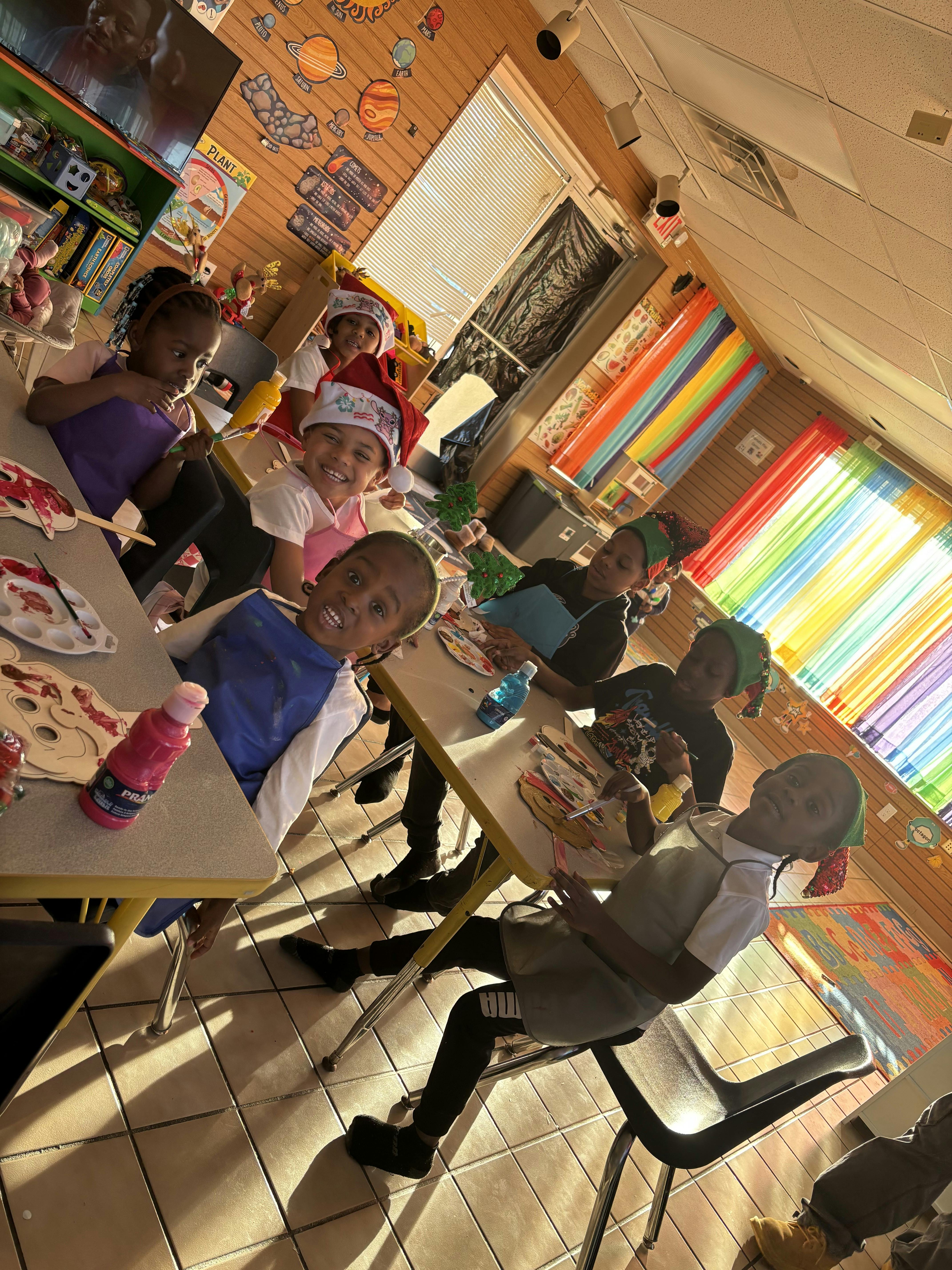 Children painting at tables in a classroom