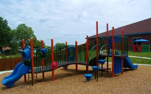 Playground with blue slides and red and green structures
