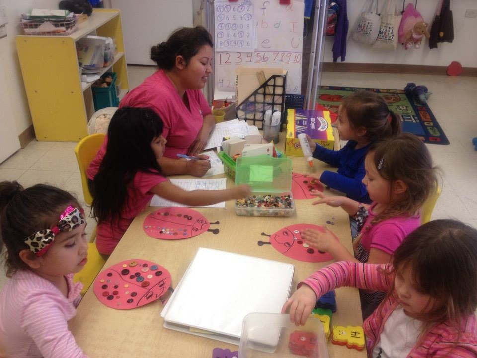 Adult and children at a table in a classroom