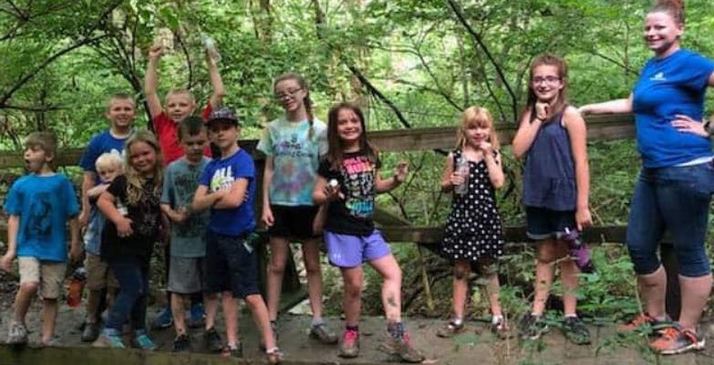 Group of children and an adult standing outdoors