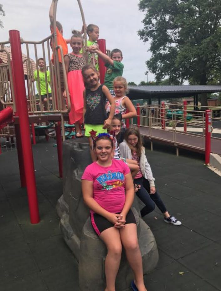 Group of children and teens on playground equipment