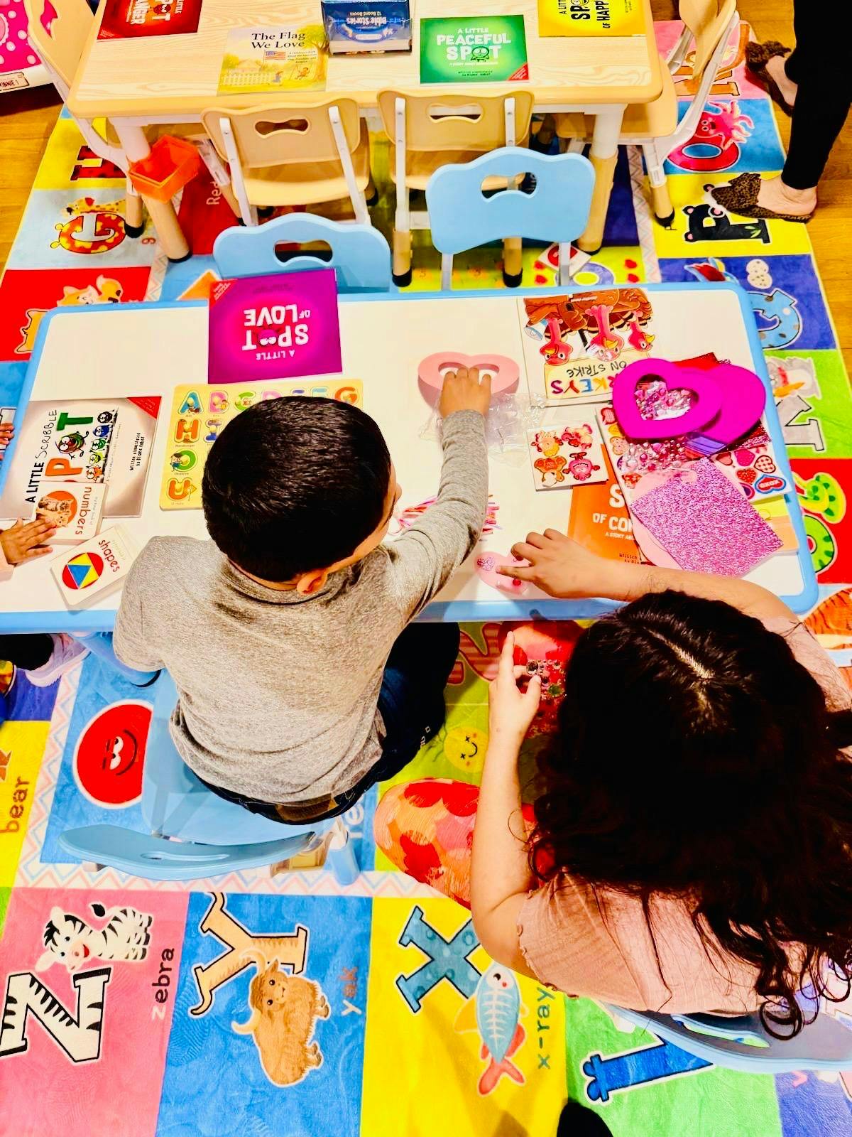 People doing crafts at a table in a classroom
