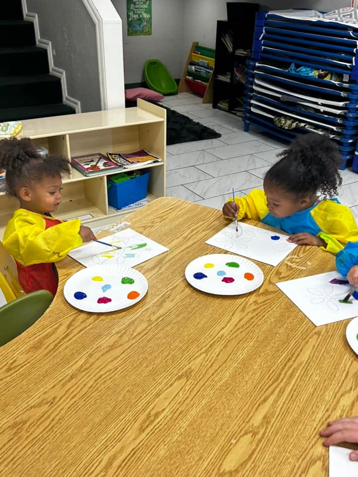 Two children painting at a table