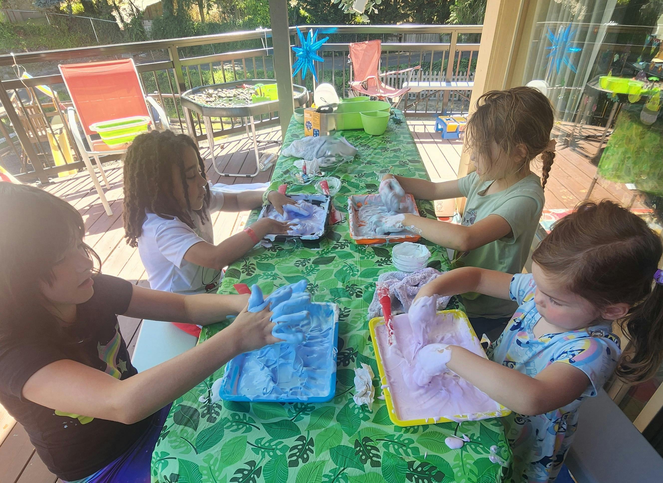 Children playing with colorful foam at a table