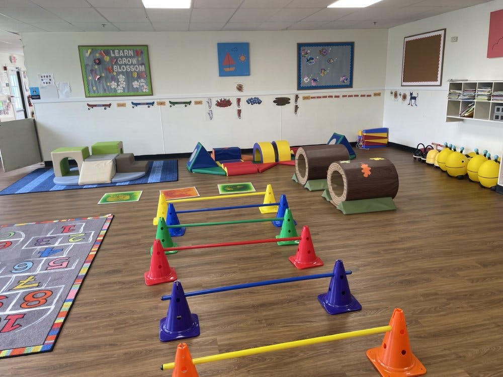 Colorful indoor play area with cones, tunnels, and a hopscotch mat