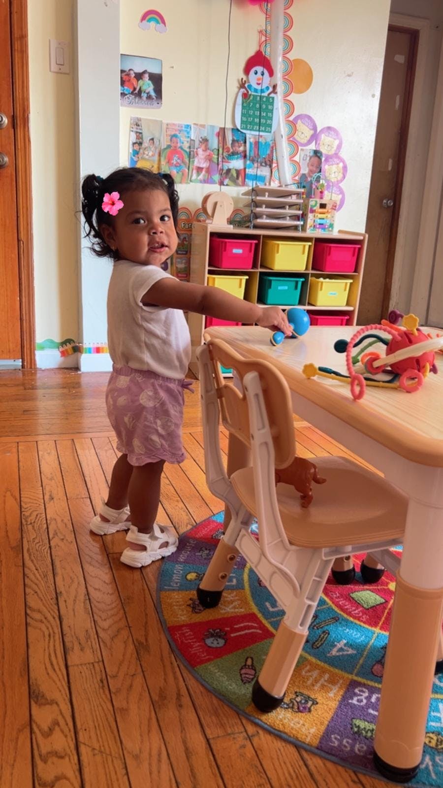 Child standing by a play table in a room