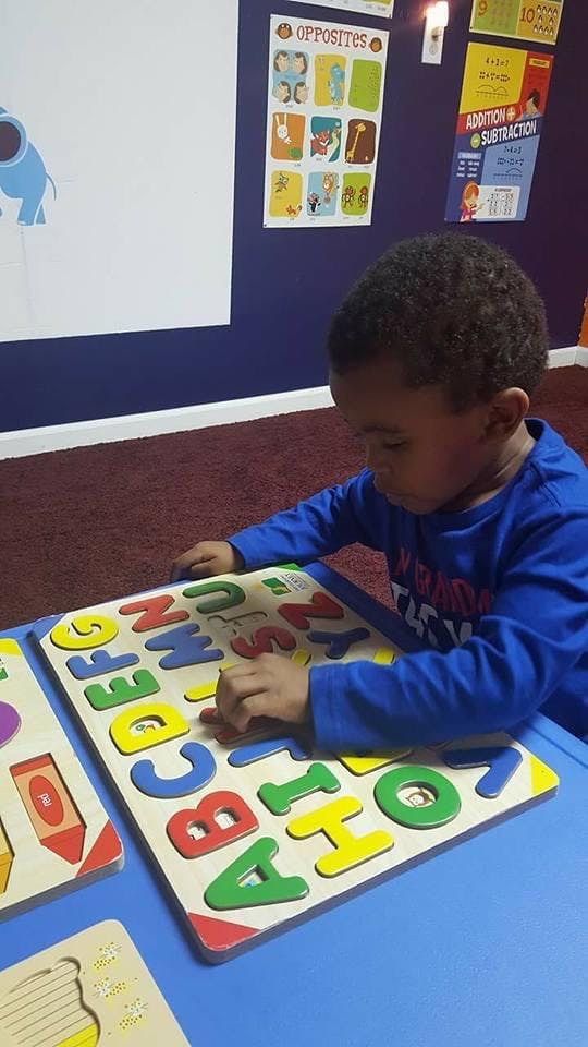 Child playing with an alphabet puzzle
