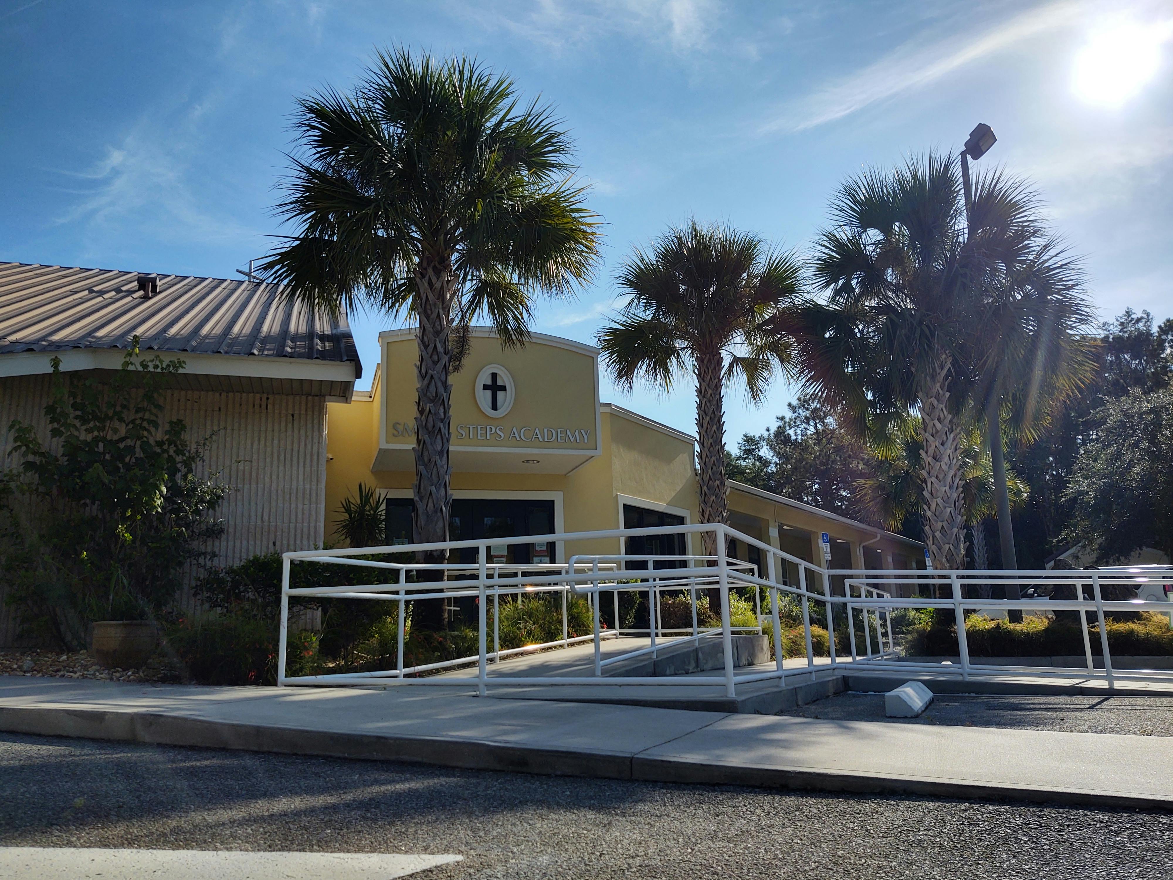 Small Steps Academy building exterior with palm trees and a wheelchair ramp