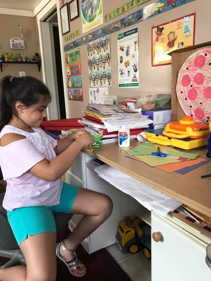 Child sitting at a desk doing crafts